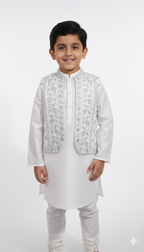 Little boy smiling wearing white kurta pajama with silver embroidered waistcoat for wedding